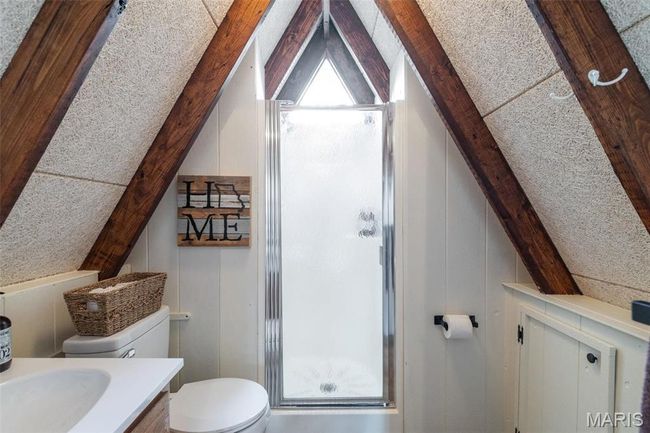 Bathroom with vanity, lofted ceiling with beams, toilet, and a stall shower | Image 41