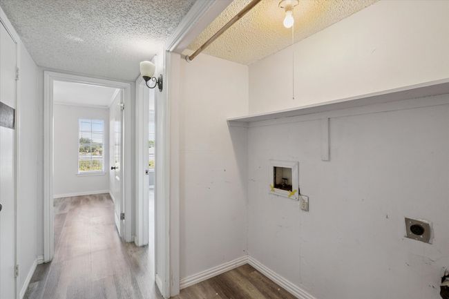 Laundry area featuring wood finished floors, hookup for a washing machine, a textured ceiling, and hookup for an electric dryer | Image 10