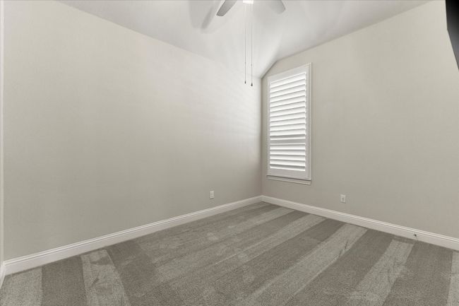 sparebed room featuring ceiling fan, carpet, vaulted ceiling & plantation shutters | Image 7