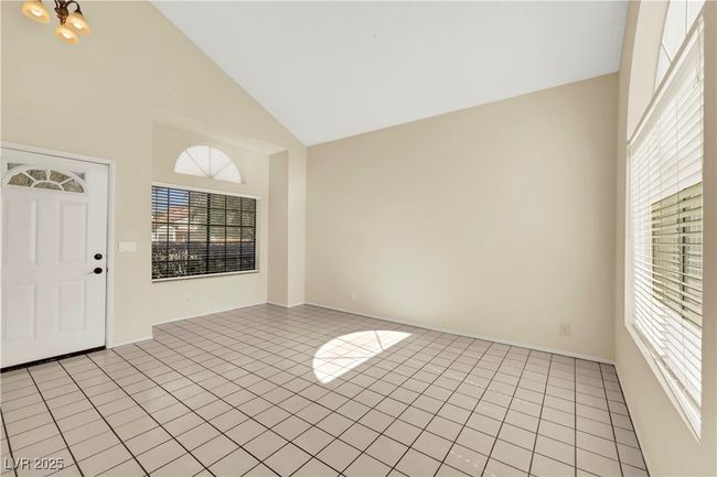 Spare room featuring high vaulted ceiling and light tile patterned floors | Image 4