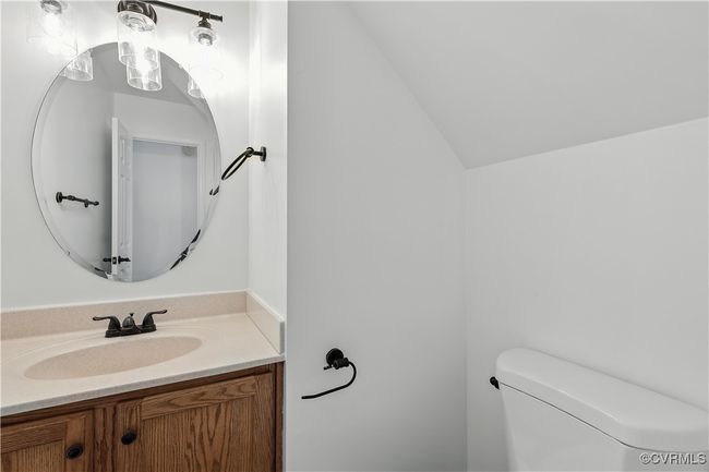 Half bathroom featuring vanity and vaulted ceiling | Image 14