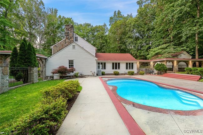 Enjoy year-round luxury with this 16' x 36' heated pool, featuring an automatic cover, paver hardscape, lush landscaping, and a secure fenced-in surround. | Image 5