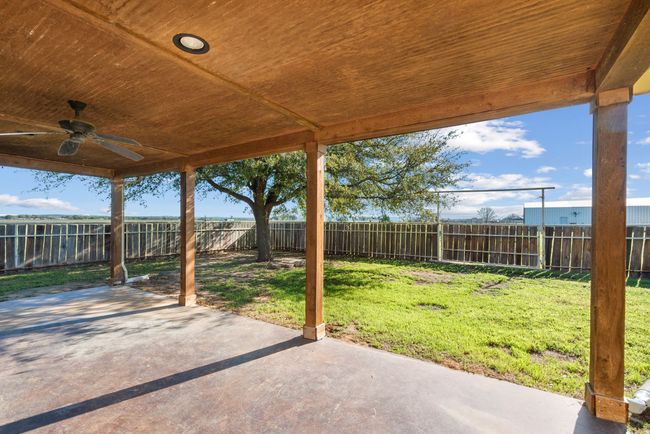 Fenced backyard featuring ceiling fan and a patio area | Image 25