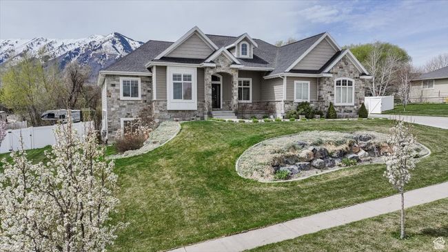 Craftsman-style home with stone siding, a front lawn, and fence | Image 16