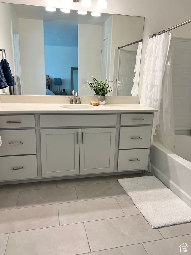Ensuite bathroom featuring vanity, shower / bathtub combination with curtain, and tile patterned flooring | Image 13