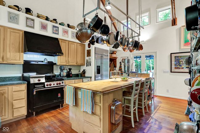 Cook's kitchen featuring exhaust hood, premium appliances (Wolf range), a high ceiling, butcher block countertops, and Cherry hardwood flooring | Image 8