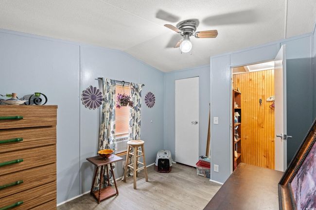 Bedroom with lofted ceiling, light wood-type flooring, ceiling fan, and cooling unit | Image 17