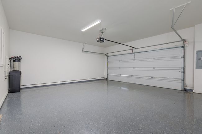 Garage featuring electric panel and a garage door opener | Image 26