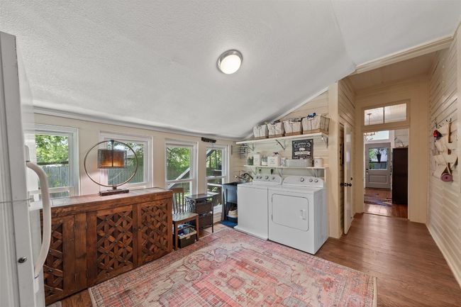 Laundry area with washing machine and clothes dryer, wood finished floors, wooden walls, and a textured ceiling | Image 14