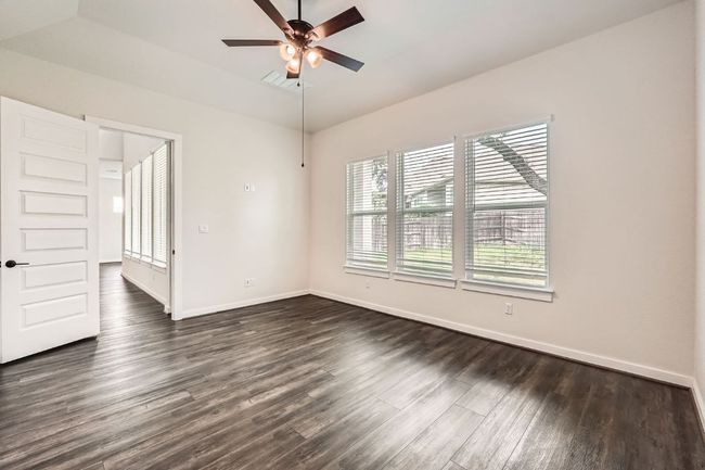 Unfurnished room with healthy amount of natural light, dark wood finished floors, a ceiling fan, baseboards, and lofted ceiling | Image 14