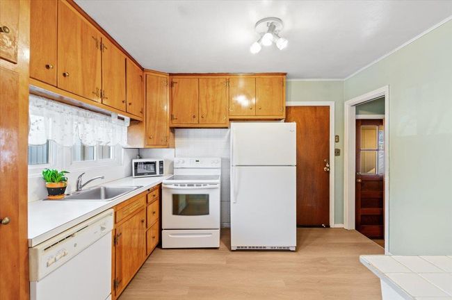 Kitchen featuring crown molding, white appliances, sink, and light wood-type flooring | Image 6
