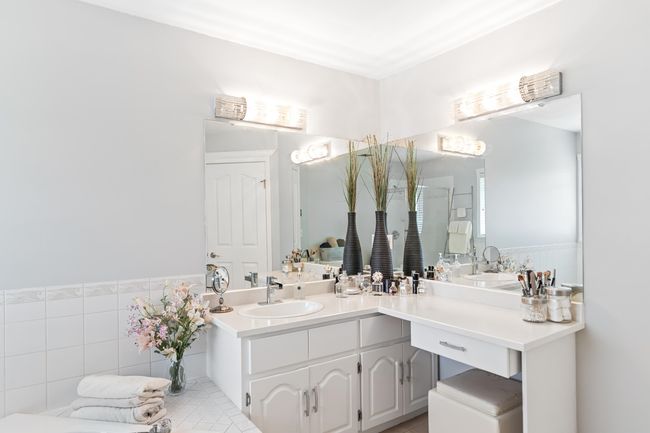 Full bathroom featuring tile walls, a shower stall, vanity, and a wainscoted wall | Image 23