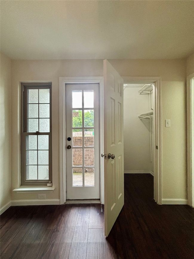 Bedroom with private patio, walk in closet, and dark wood finished floors | Image 23
