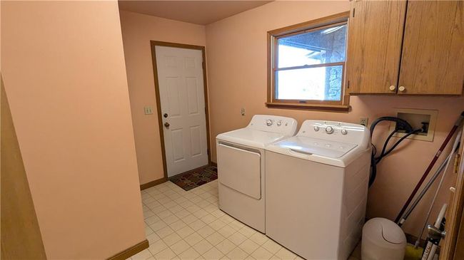 Clothes washing area featuring cabinets and washing machine and clothes dryer | Image 21