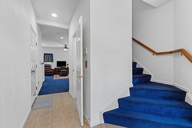 Stairs lead to the upper level or walk straight into the family room. | Image 6
