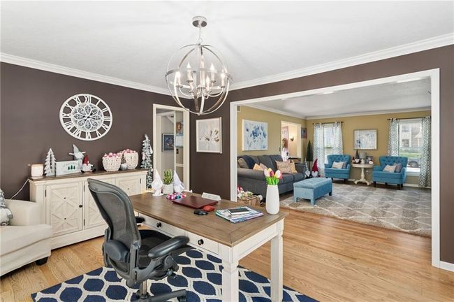 Office area featuring ornamental molding, a notable chandelier, and light wood-type flooring | Image 10