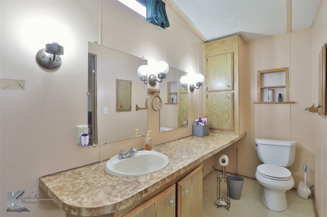 Bathroom with vanity, vaulted ceiling, and toilet | Image 29