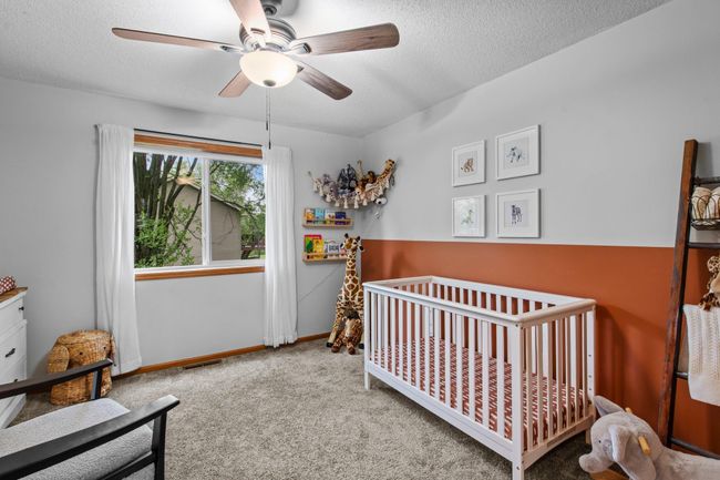 The second bedroom on the upper level features room darkening shades, a wide closet, and new fan (2023) | Image 13
