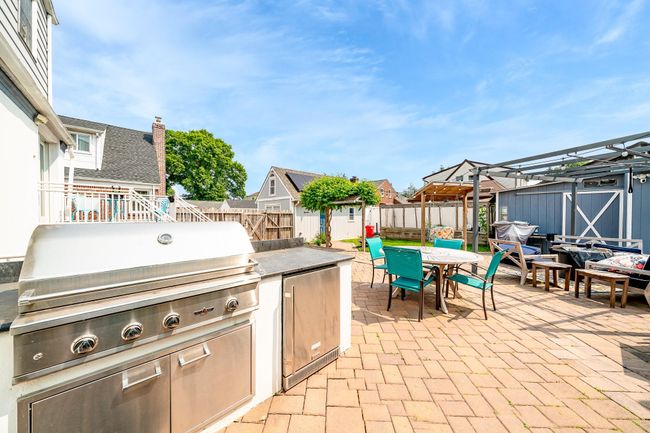Fenced backyard featuring outdoor dining area, a patio, and a residential view | Image 5