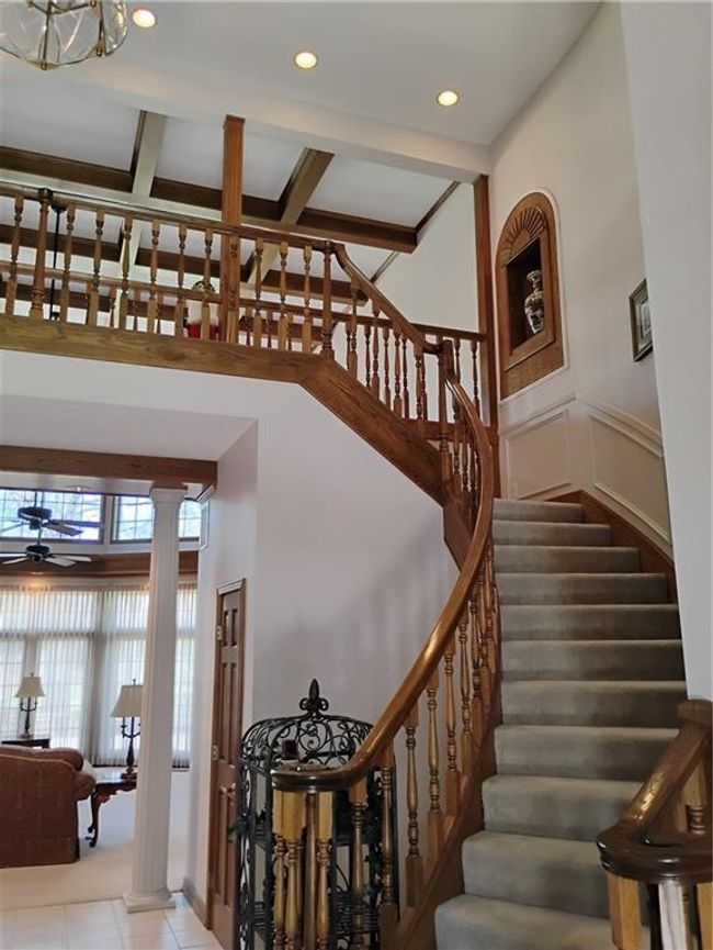 Staircase featuring a wainscoted wall, recessed lighting, ornate columns, a ceiling fan, and tile patterned flooring | Image 16