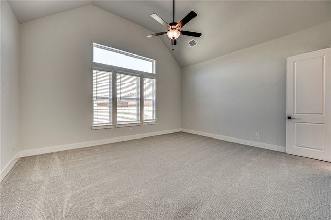 Unfurnished room with baseboards, a ceiling fan, visible vents, high vaulted ceiling, and carpet | Image 11