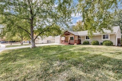 Single story home with a wooden deck and a front lawn | Image 2