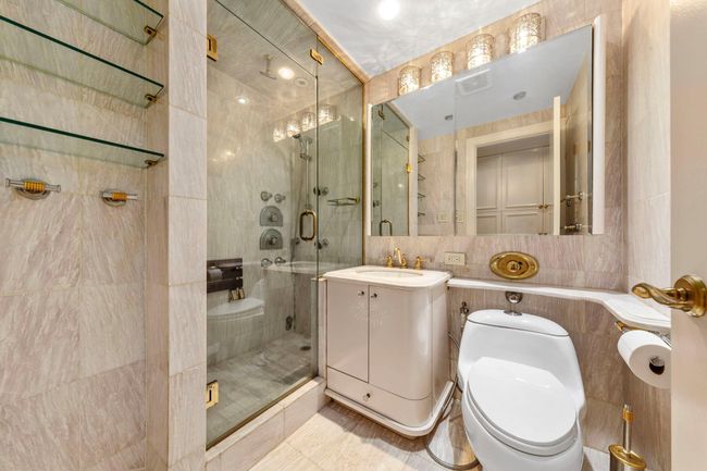 Bathroom with tile walls, a stall shower, and vanity | Image 20