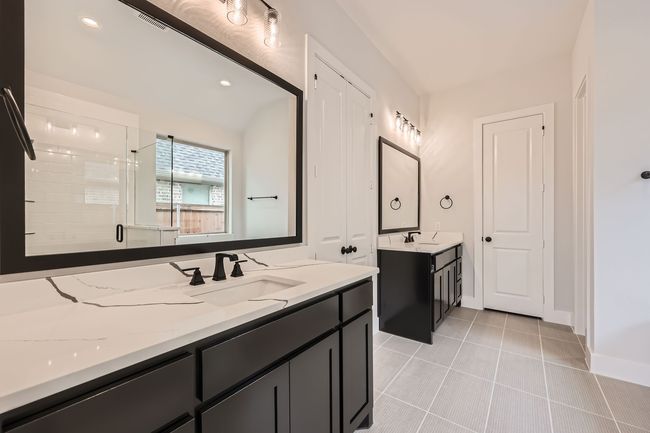Bathroom featuring a shower stall, tile patterned floors, a sink, visible vents, and two vanities | Image 16