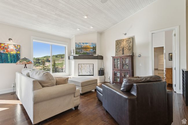 Living room with lofted ceiling, wooden ceiling, and dark wood finished floors | Image 12