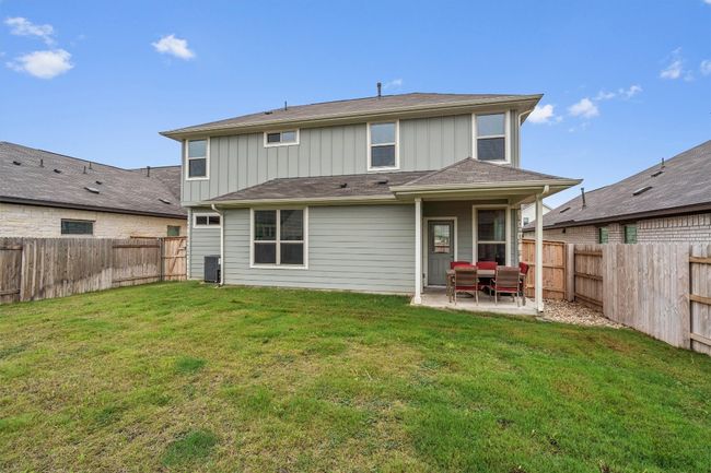 Rear view of property with board and batten siding, a patio area, and central AC unit | Image 32