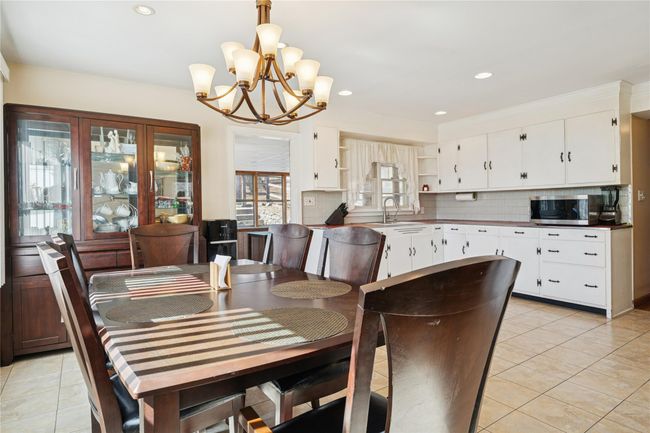Dining area with a notable chandelier, recessed lighting, and light tile patterned floors | Image 17