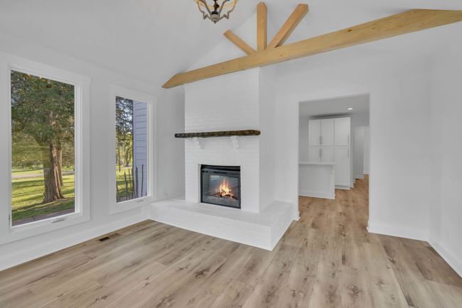 Great view of the beam. Brick hearth and fireplace with wooden mantle. | Image 19