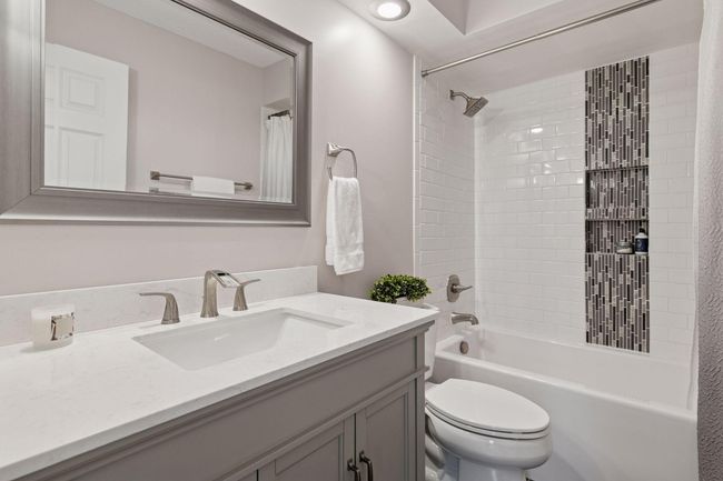 Full bathroom on main level was remodeled in 2020: subway tile surround with tile inlay and alcove, soaker tub, quartz vanity, brushed nickel Delta fixtures | Image 27