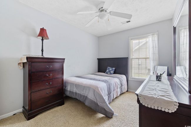 Bedroom featuring light carpet, a textured ceiling, and a ceiling fan | Image 7