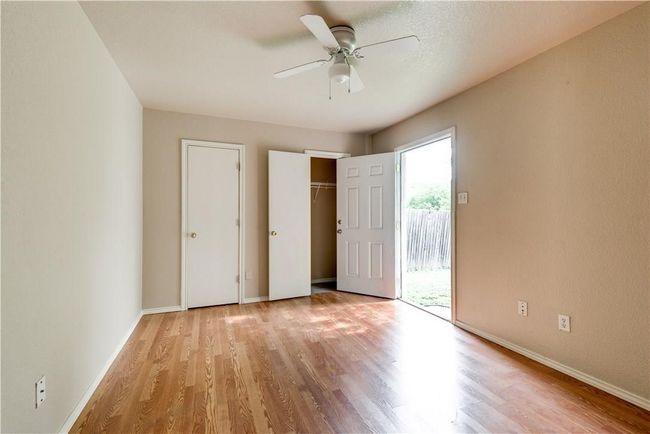Unfurnished bedroom featuring access to outside, wood finished floors, a ceiling fan, and a closet | Image 5