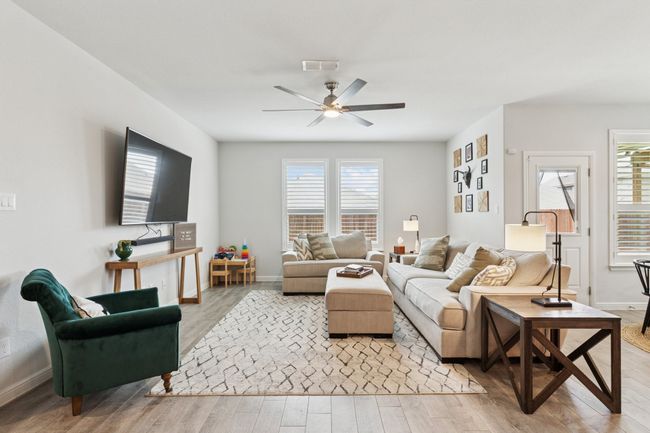 Living area featuring light wood finished floors, healthy amount of natural light, and ceiling fan | Image 6
