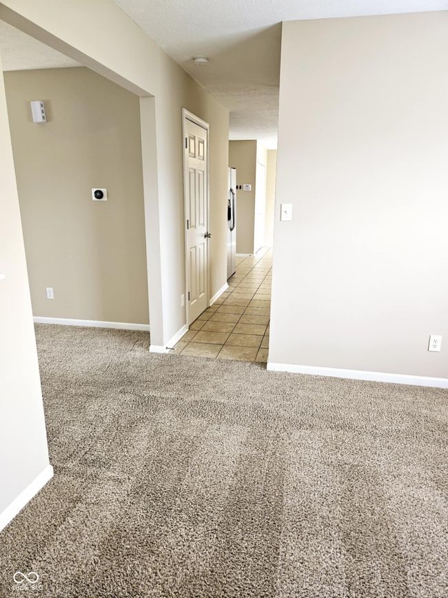 unfurnished room featuring light tile patterned floors, baseboards, and light carpet | Image 15