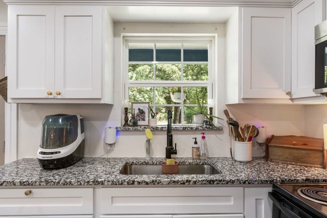 Kitchen with white cabinets, dark stone counters, and stainless steel microwave | Image 9