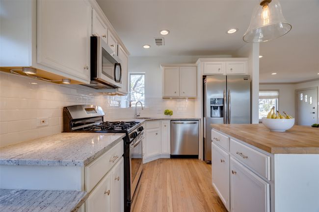 Kitchen featuring wood counters, a wealth of natural light, appliances with stainless steel finishes, and a sink | Image 7