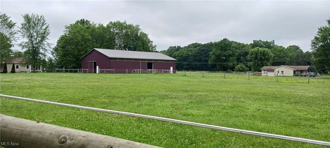 View of green lawn with an outdoor structure, an exterior structure, an outbuilding, and a view of countryside | Image 19