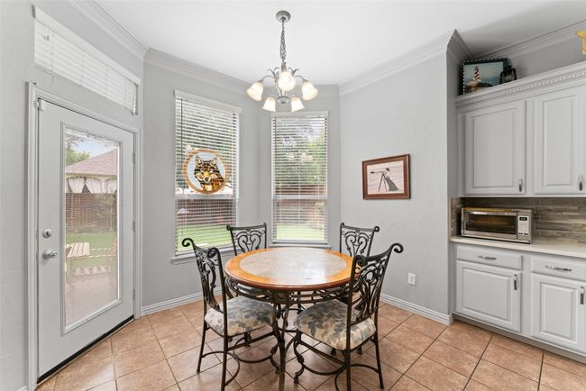 Dining space with a chandelier, light tile patterned flooring, and ornamental molding | Image 7