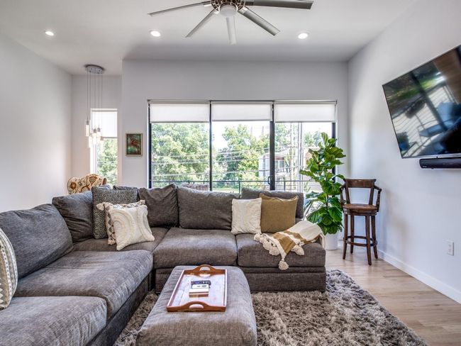 Living room featuring healthy amount of natural light, ceiling fan, light wood finished floors, and recessed lighting | Image 8