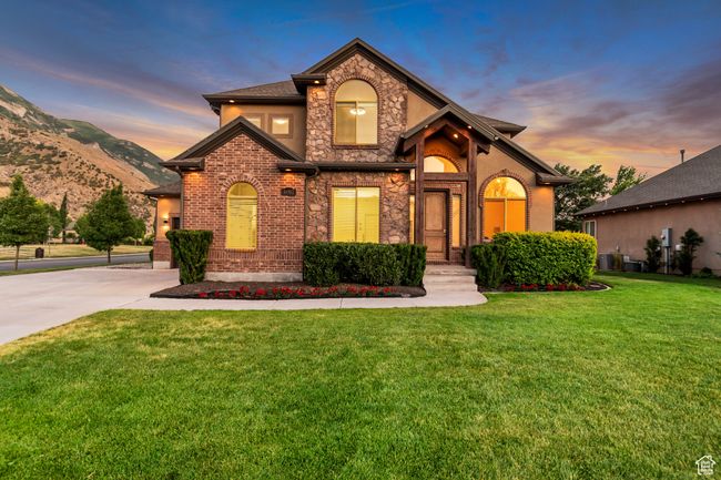 View of front of home with a front yard, concrete driveway, stucco siding, stone siding, and a mountain view | Image 37