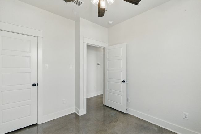 Unfurnished bedroom with finished concrete flooring and baseboards | Image 20