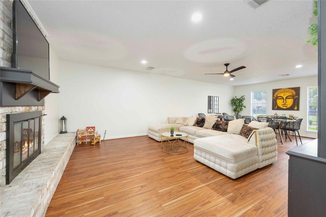 Large windows surround the living room, flooding the open-concept layout with natural light and enhancing the bright, airy atmosphere. | Image 8