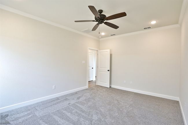 Carpeted room featuring crown molding, a ceiling fan, and recessed lighting | Image 14