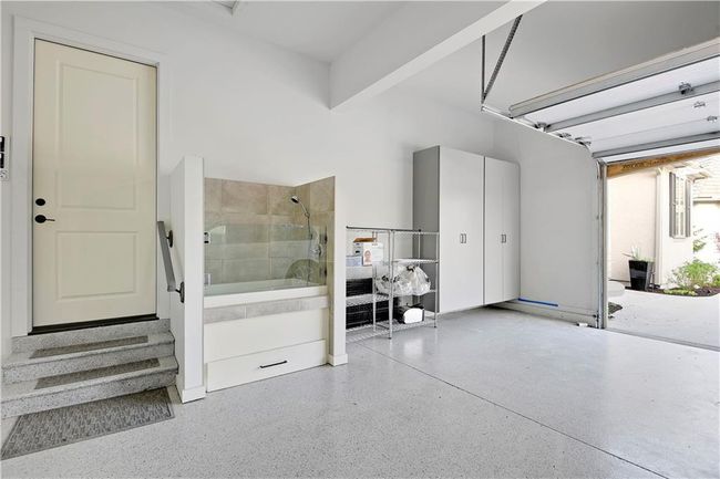 Living area featuring wet bar, a glass covered fireplace, light wood-style floors, beamed ceiling, and beverage cooler | Image 44
