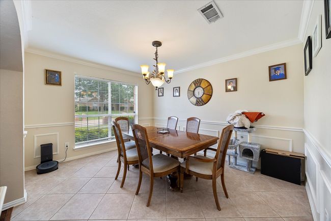 Dining space with a chandelier, crown molding, and light tile patterned floors | Image 10