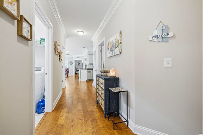 Corridor featuring crown molding, light wood finished floors, and baseboards | Image 7