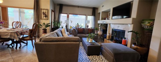 Living area with light tile patterned floors and a tile fireplace | Image 9